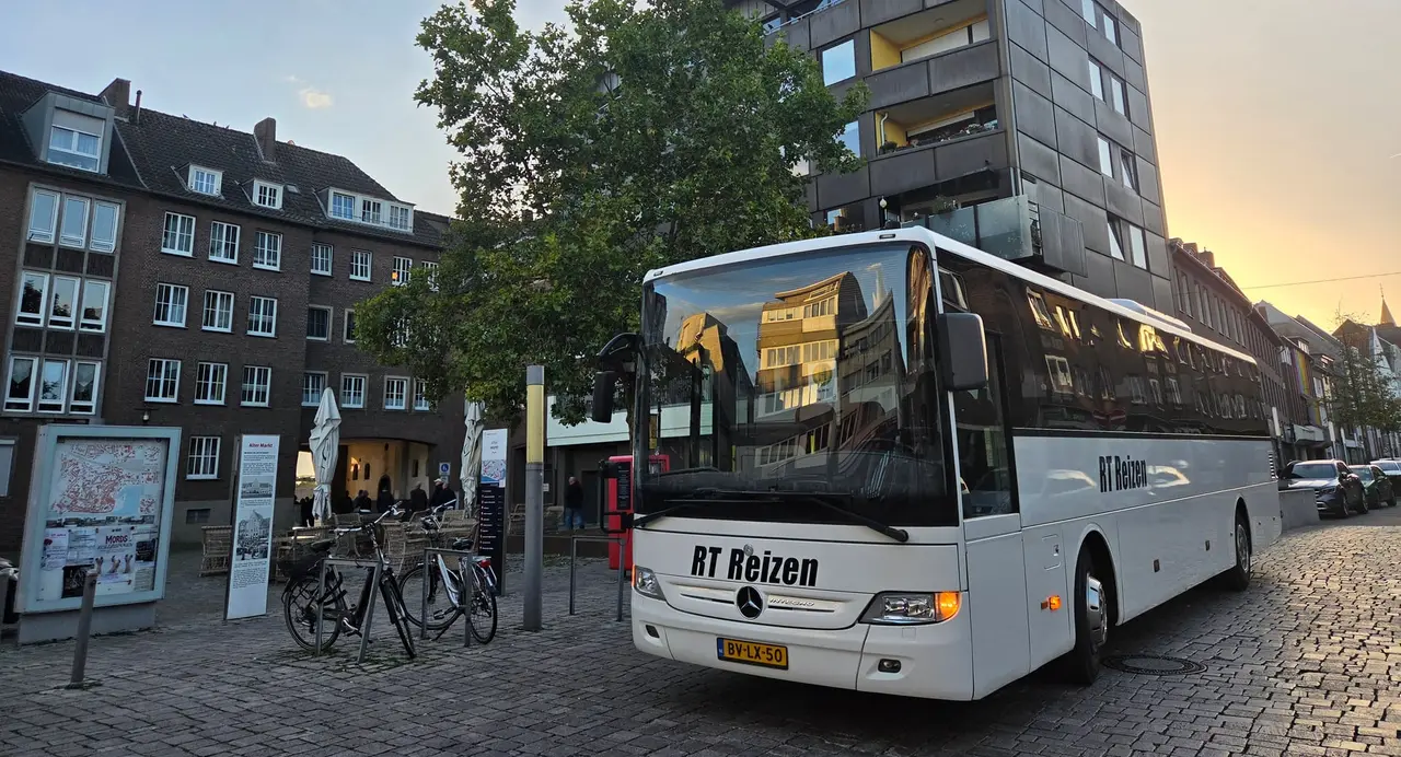 Reisebus von RT Reizen am Alten Markt in Emmerich im Abendlicht.