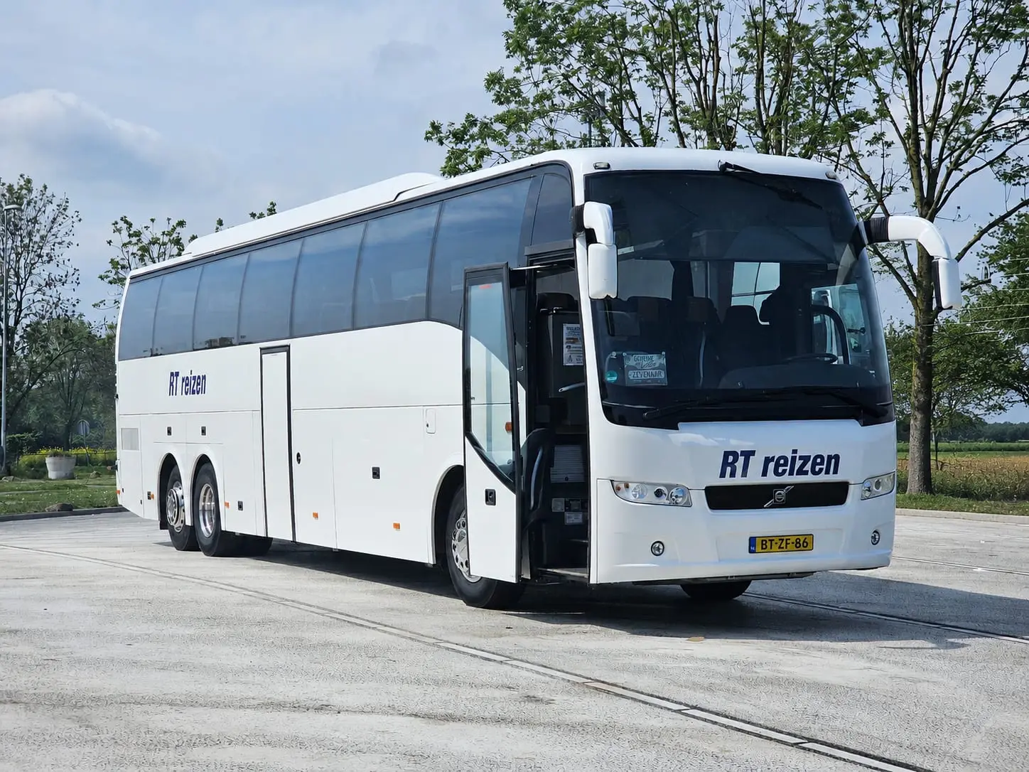 Touringcar van RT Reizen driekwart van voren op een lege parkeerplaats, kenteken BT-ZF-86.